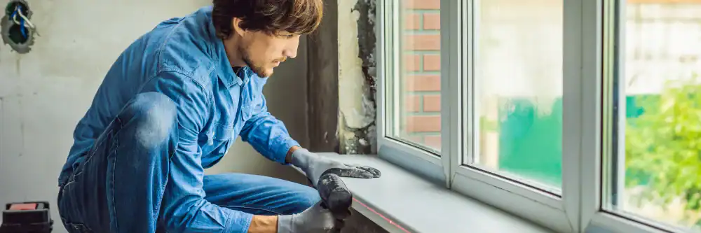 Man expertly installing a window seal on a home in Talbot County, Maryland, enhancing energy efficiency and weather protection for Bay Area Exteriors