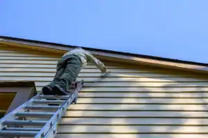 Exterior house painting in Talbot County, Maryland, with professional crew using ladder to reach upper siding, showcasing Bay Area Exteriors’ quality craftsmanship