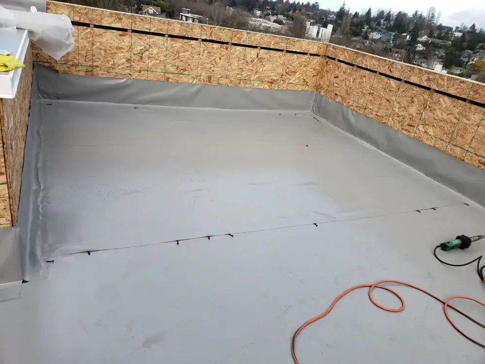 Rooftop construction with wet surface in Talbot County, MD, showcasing Bay Area Exteriors team performing precision roofing work in rainy conditions